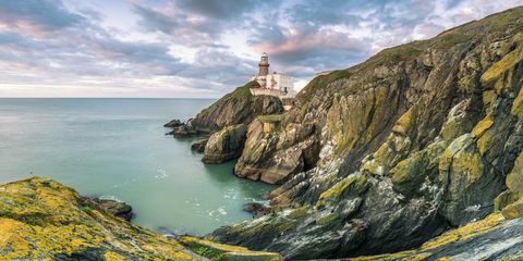 Baily tuletorn, Howth, Dublini krahvkond, Iirimaa, Euroopa. Panoraamvaade kaljule ja tuletornile päikesetõusul.