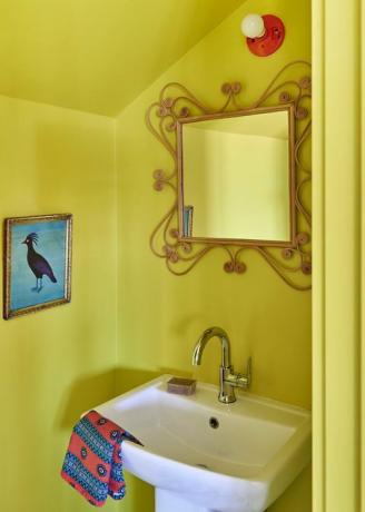 kollane pulberruum, kollase värviga seinad valge kraanikausiga, lindude kunstiteos